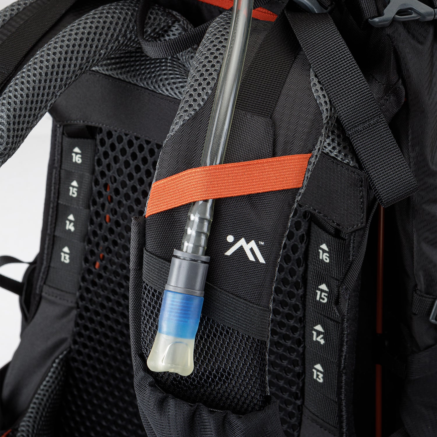 Close-up of hydration sleeve with blue drinking tube routed through shoulder strap.