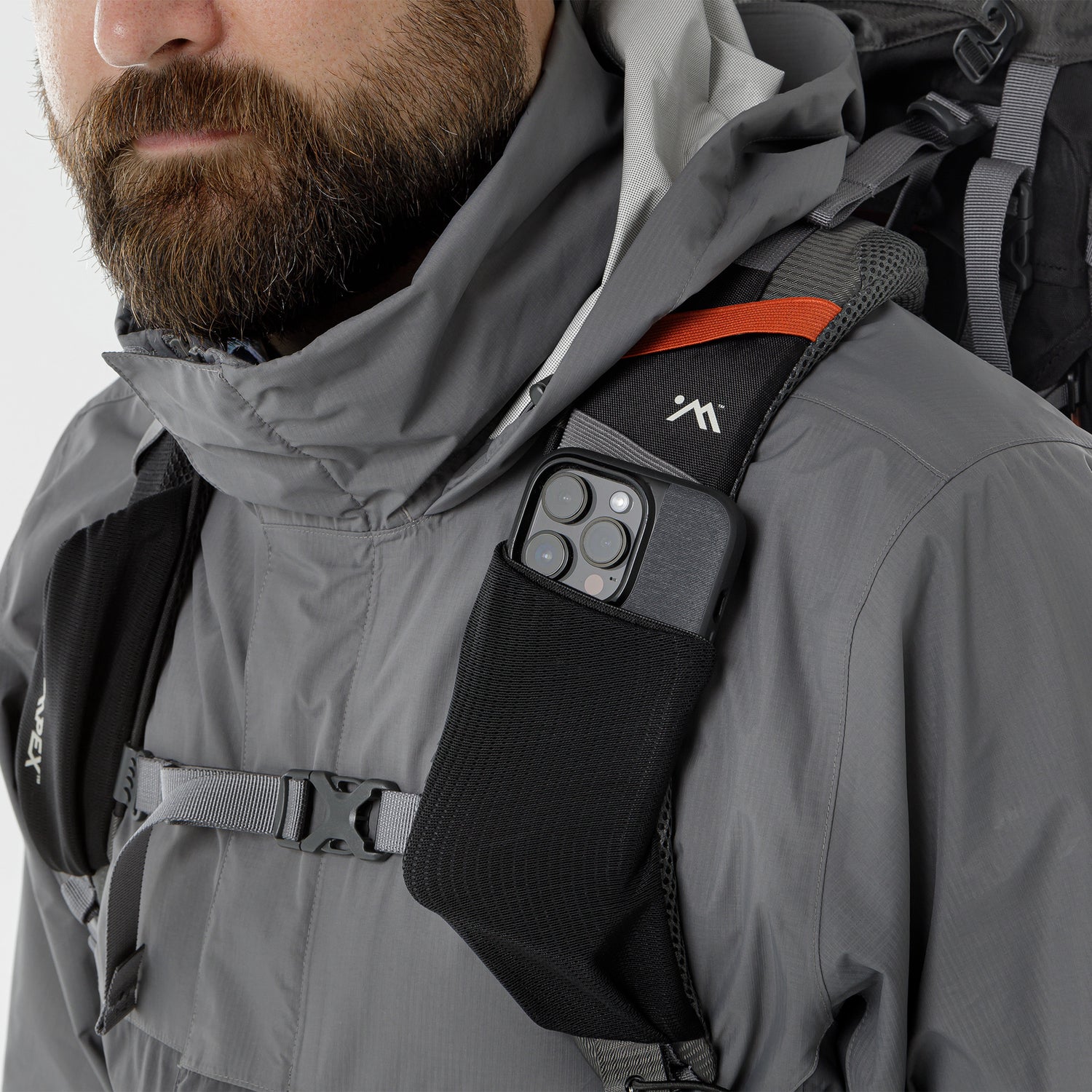 Close-up of a small pocket on the backpack shoulder strap holding a smartphone.