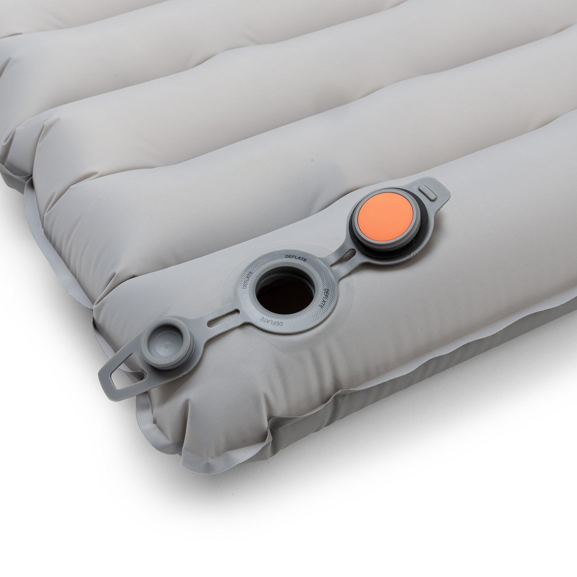 Close-up of the sleeping pad showing the valve open with orange interior visible for airflow release.