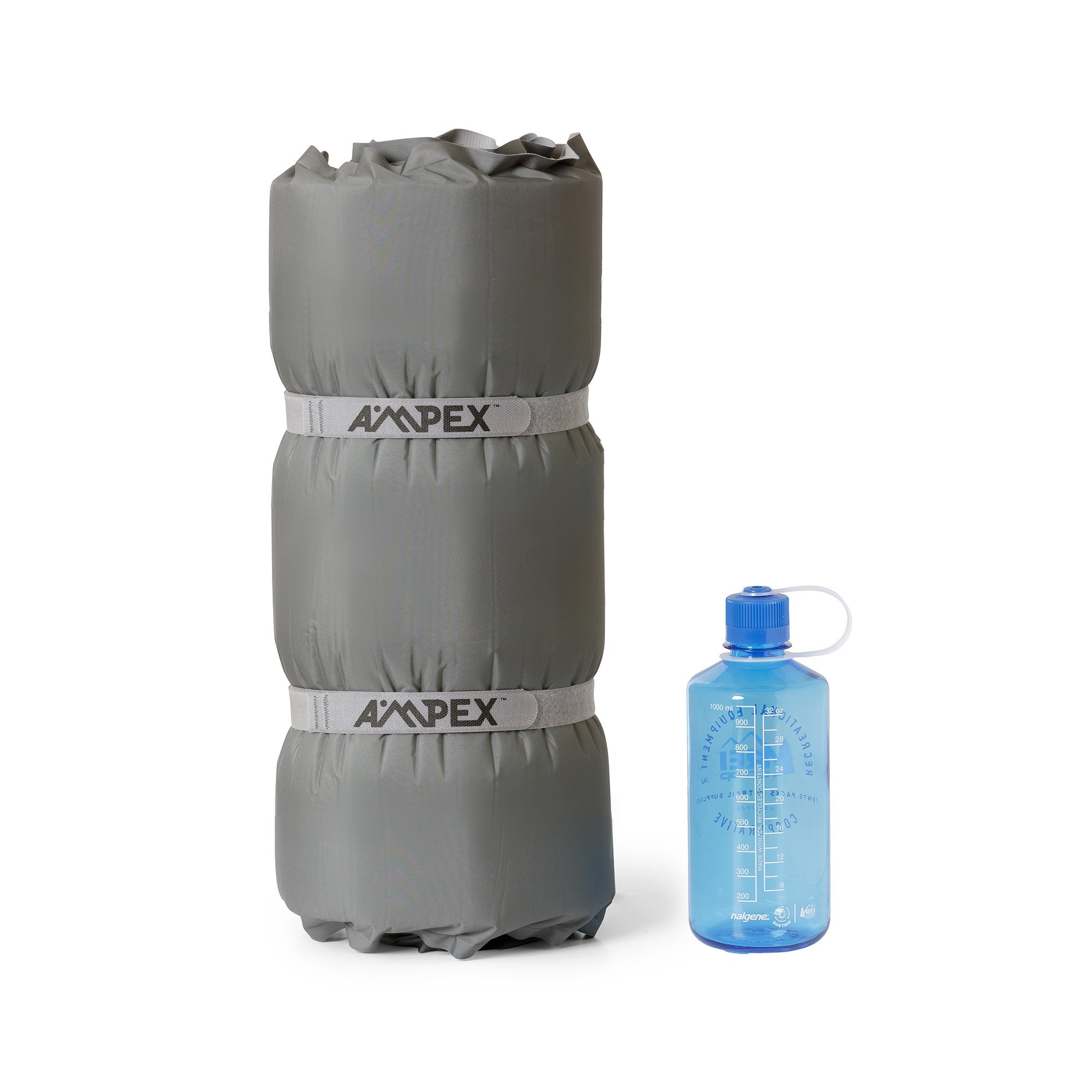 Sleeping pad rolled up, with blue water bottle beside it.
