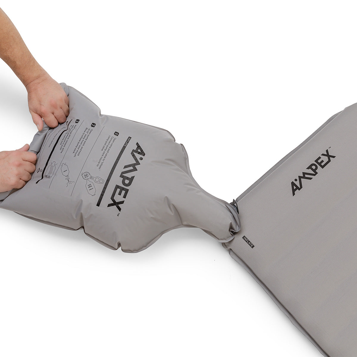 Sleeping pad with Ampex logo being inflated with a gray pump sack.