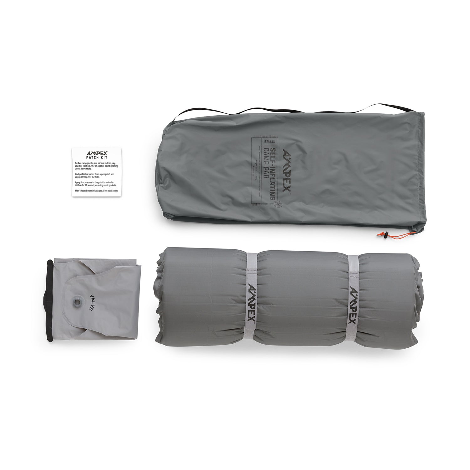 Sleeping pad with included accessories laid out—gray storage bag, patch kit pouch, pump sack, and pad.