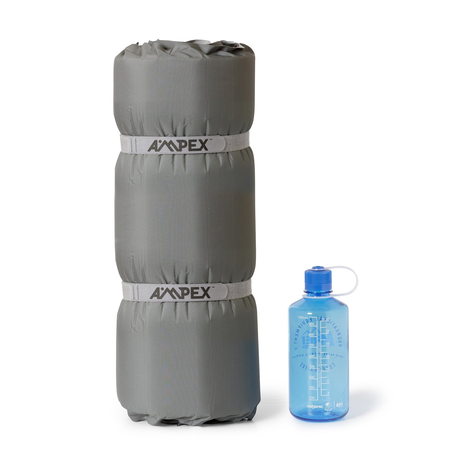 Sleeping pad rolled up, with blue water bottle beside it.