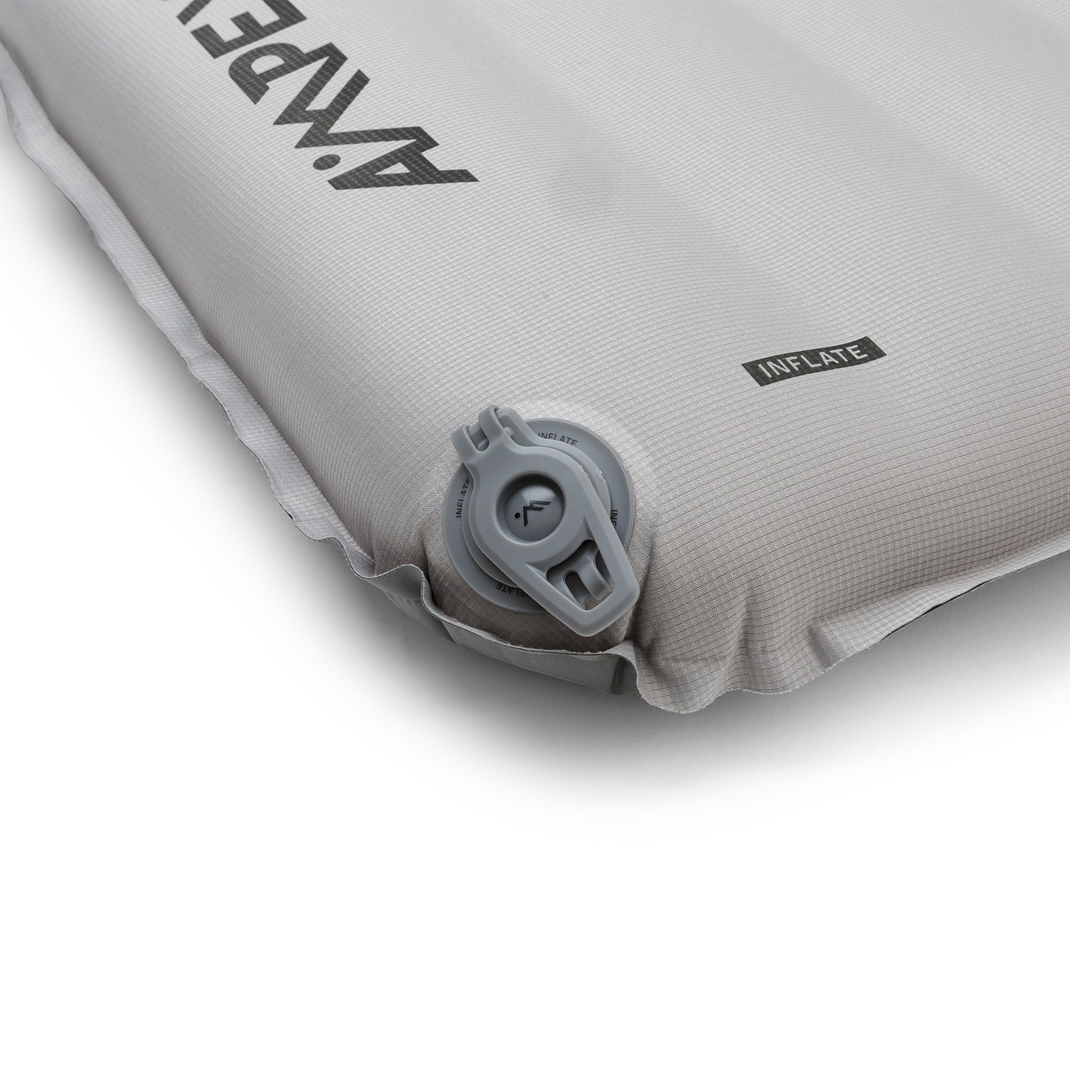 Close-up of the pad’s side corner with inflation valve, textured fabric, and printed instructions.