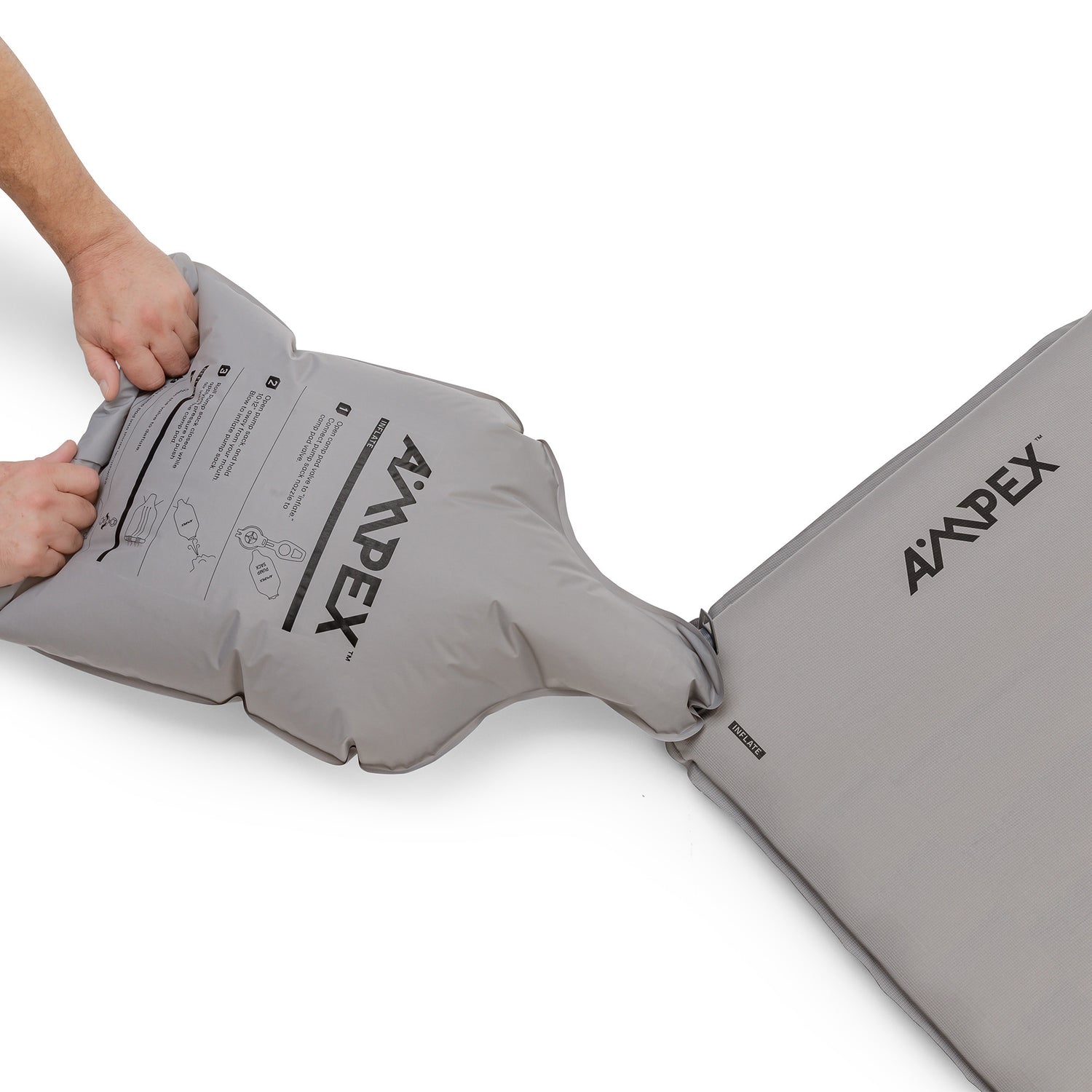 Sleeping pad with Ampex logo being inflated with a gray pump sack.