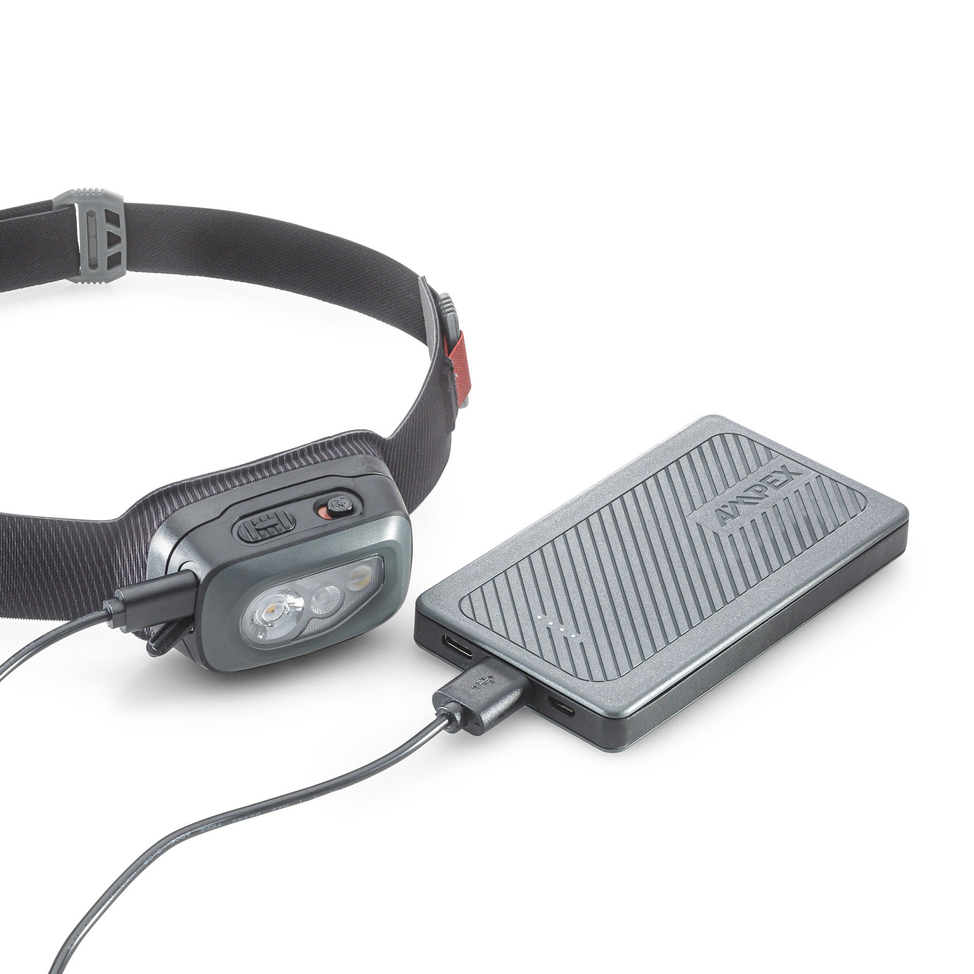 The 5000 mAh power bank charging a headlamp device using a cable.