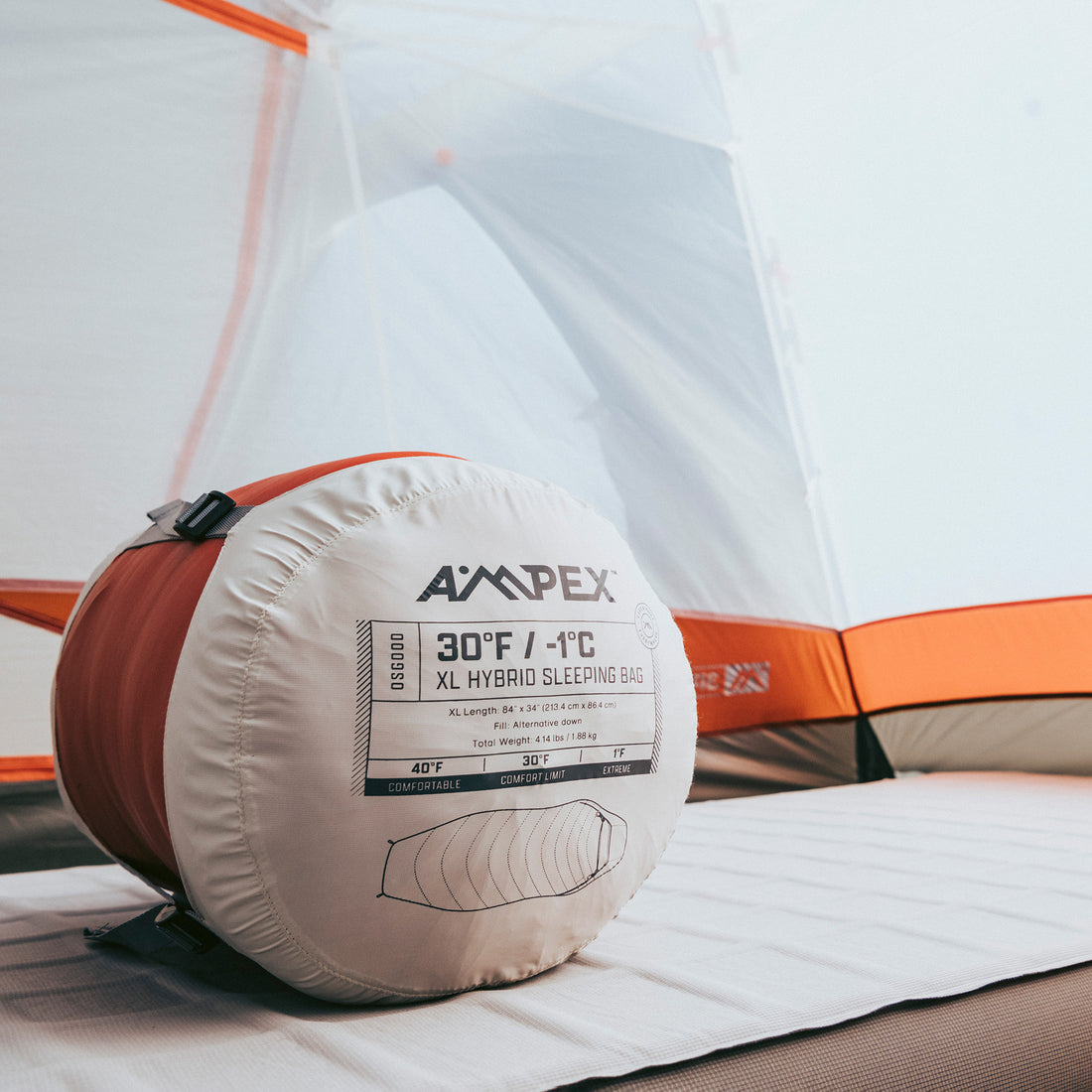 Sleeping bag inside its compression sack resting in a tent corner.