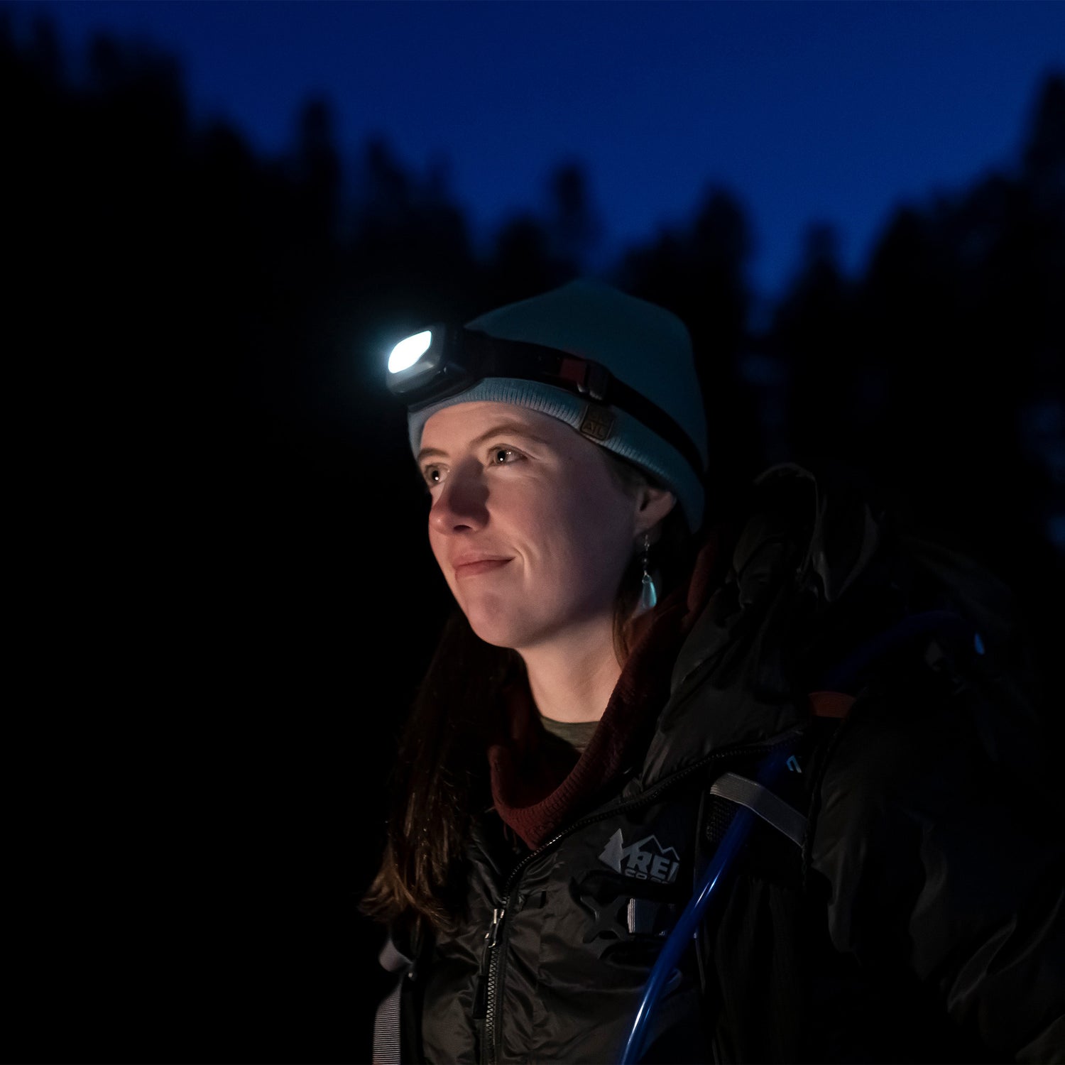 A person wearing the 300 Lumen AMPEX headlamp while hiking at night.